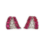 Pair of earrings shaped like upside-down triangles with ruby border surrounding pave diamond centers