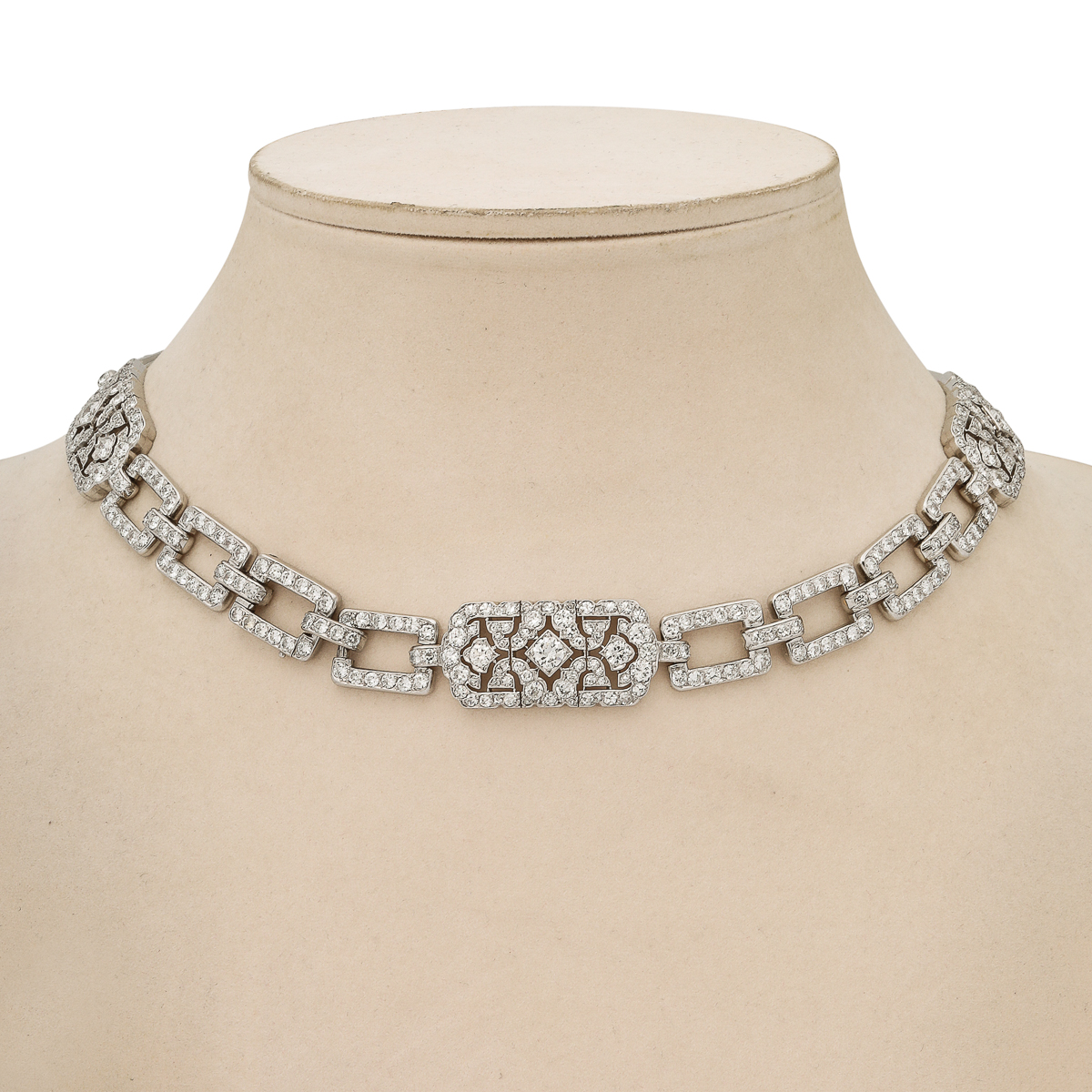 Diamond and platinum link necklace photographed on beige neck block.