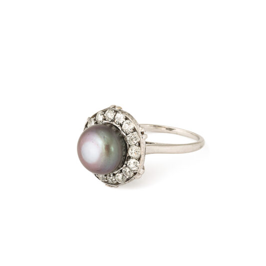 three quarter view of black button pearl and diamond ring