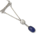 another detail view of seed pearl and diamond necklace suspending a cabochon sapphire