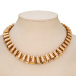 gold wave design necklace on a neck block